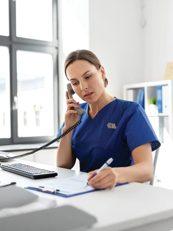 Woman wearing a medical workwear with CBWM's logo embroidery