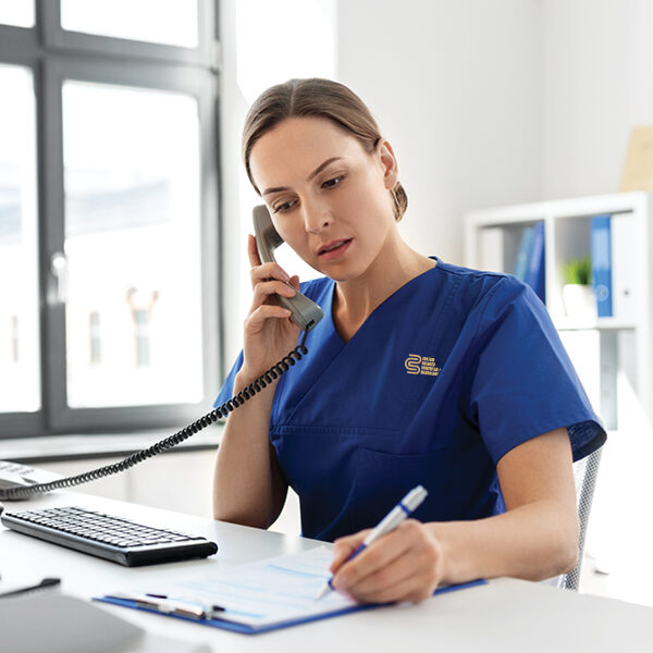 Woman wearing a medical workwear with CBWM's logo embroidery
