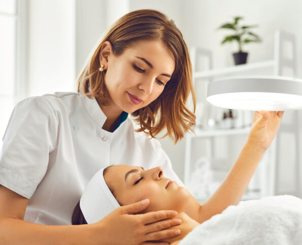 Woman giving skin treatment wearing hospitality workwear without logo embroidery