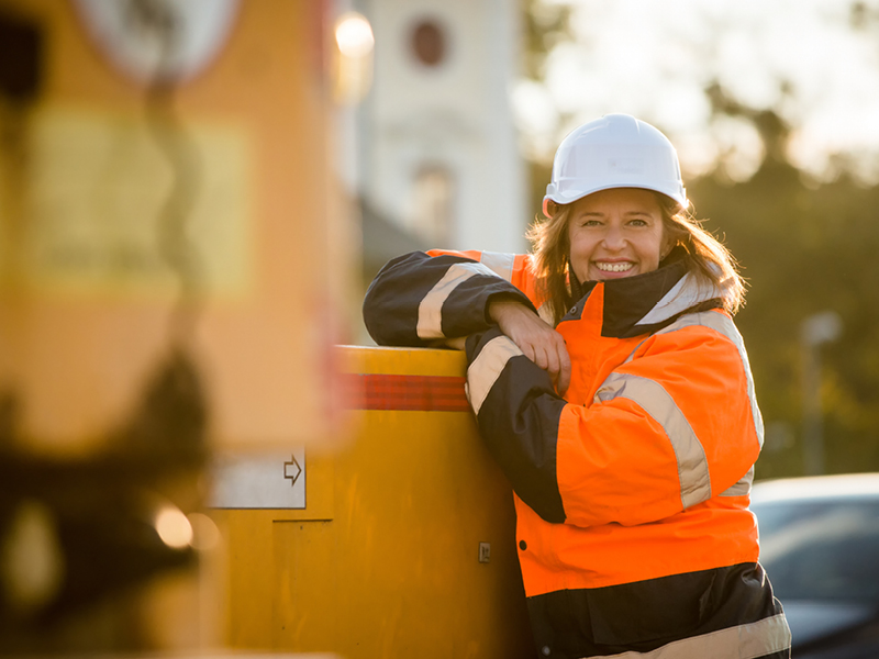 Woman showcasing the heat transfer printing method applied on her hi-vis workwear
